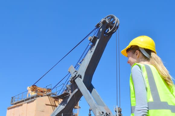 A woman standing in front on mining equipment