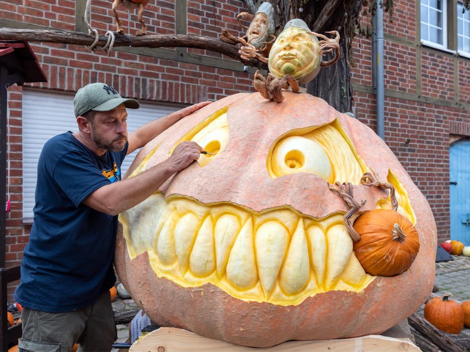 Rick Reiski, a pumpkin carver, is pictured working on a 1,124-pound pumpkin.