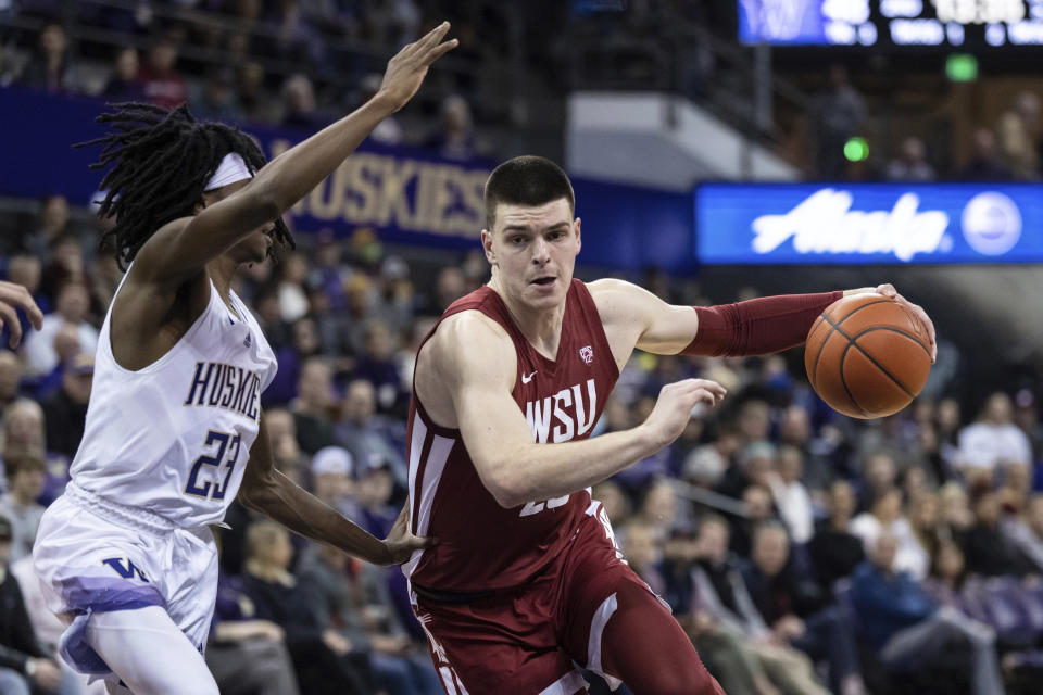 Washington State forward Andrej Jakimovski drives against Washington guard Keyon Menifield during the second half of an NCAA college basketball game Thursday, March 2, 2023, in Seattle. Washington State won 93-84. (AP Photo/Stephen Brashear)