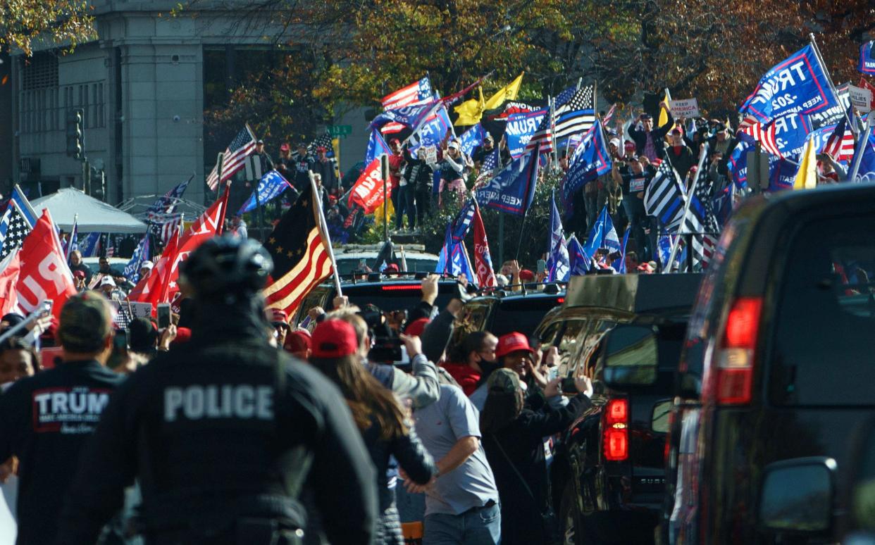 The motorcade of US President Donald Trump drives past supporters holding a rally in Washington, DC, on 14 November, 2020 (AFP via Getty Images)