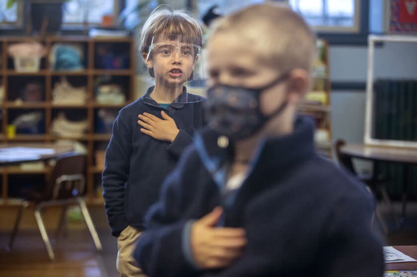 GRASS VALLEY, CA - FEBRUARY 24: Kindergartener Kieran Ryan, left, holds his hand over his heart during Pledge of Allegiance at Mount St. Mary's Academy on Wednesday, Feb. 24, 2021 in Grass Valley, CA. The elementary school, part of the Catholic Diocese of Sacramento, has managed to stay open with students healthy. (Brian van der Brug / Los Angeles Times)