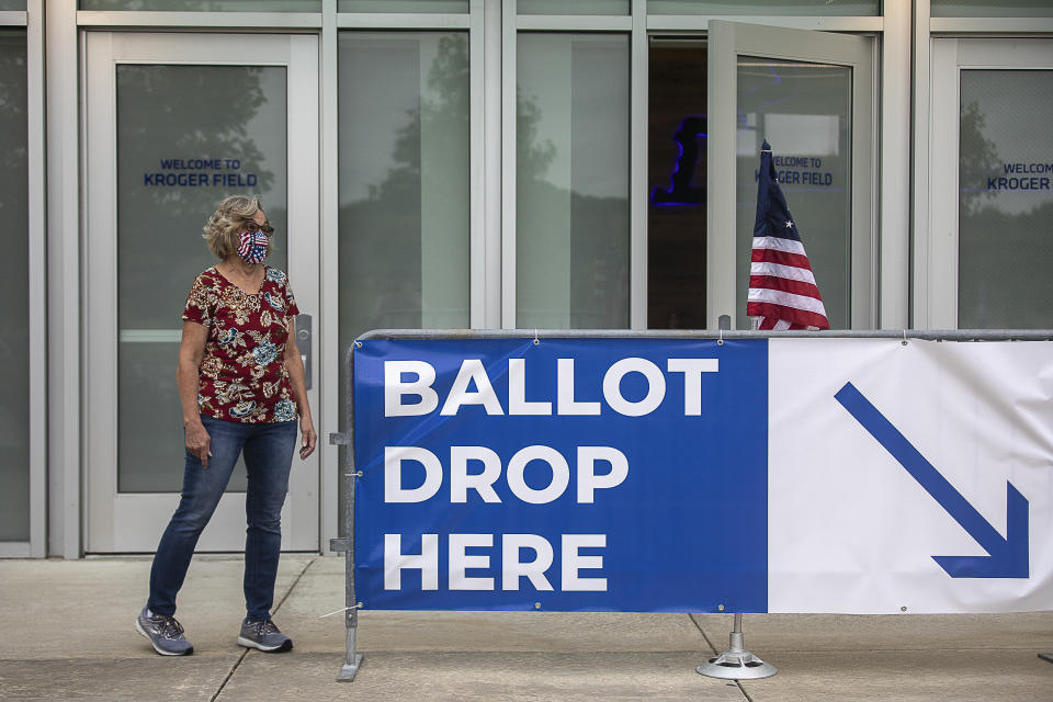 Poll worker Dolores Louallen directs Fayette County voters where to drop off their absentee ballots at Kroger Field in Lexington, Ky., on Tuesday, June 23, 2020. (Ryan C. Hermens/Lexington Herald-Leader via AP)