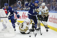 Boston Bruins' Morgan Geekie (39) falls as he battles for the puck with Toronto Maple Leafs' John Tavares (91) as Maple Leafs' Jake McCabe (22) and Bruins' Brad Marchand (63) look on during the third period in Game 6 of an NHL hockey Stanley Cup first-round playoff series in Toronto on Thursday, May 2, 2024. (Nathan Denette/The Canadian Press via AP)