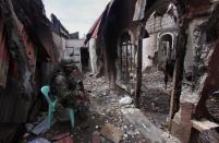 A Philippine soldier sits among burned houses destroyed during the stand-off with government forces in Zamboanga, on the southern island of Mindanao, on September 28, 2013