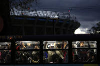 Un autobús transporta a varios pasajeros frente a un estadio Azteca en penumbra, el martes 13 de noviembre de 2018, en la Ciudad de México. En la jornada, la NFL se negó a realizar en este inmueble un partido previsto para el lunes próximo, debido a las malas condiciones de la cancha (AP Foto/Rebecca Blackwell)