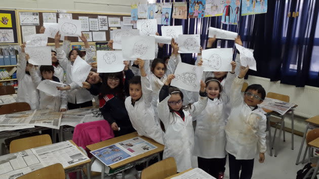 Kids in Chile hold up drawings in celebration of Asteroid Day.