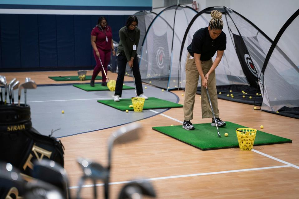 Imani Stowers, 17, of Detroit, right, practices golf during the Midnight Golf Program at Marygrove Conservancy in northwest Detroit, Tuesday, Feb. 7, 2023.