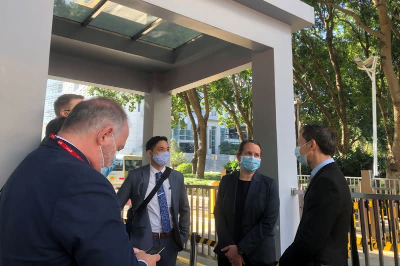 Consulate representatives stand at an entrance to a court in Shenzhen