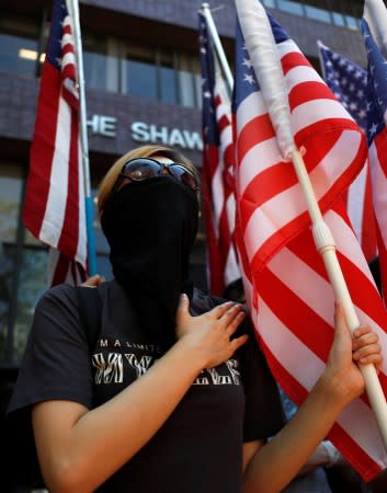 An anti-government protester holds a US flag during a rally at the University of Hong Kong