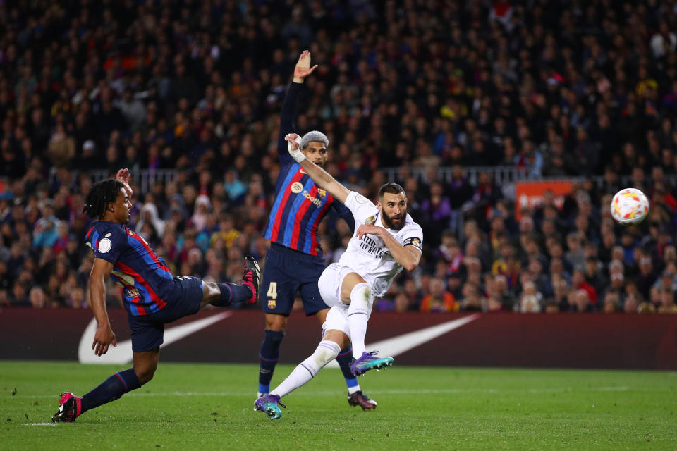 BARCELONA, SPAIN - APRIL 05: Karim Benzema of Real Madrid shoots while under pressure from Jules Kounde and Ronald Araujo of FC Barcelona during the Copa Del Rey Semi Final Second Leg match between FC Barcelona and Real Madrid CF at Spotify Camp Nou on April 05, 2023 in Barcelona, Spain. (Photo by Eric Alonso/Getty Images)