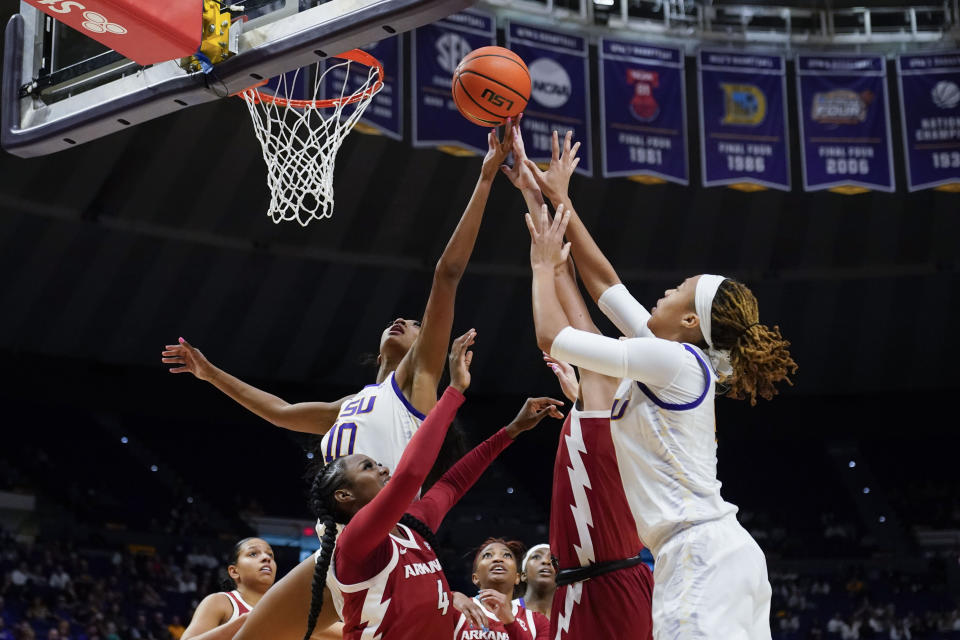 LSU forward Angel Reese (10) and forward LaDazhia Williams (0) leap for a rebound over Arkansas forward Erynn Barnum (4) in the second half an NCAA college basketball game in Baton Rouge, La., Thursday, Jan. 19, 2023. LSU won 79-76. (AP Photo/Gerald Herbert)