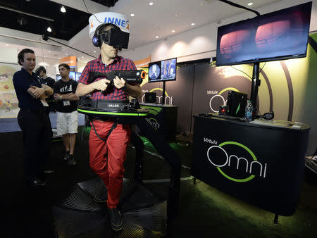 An attendee tries out the Virtuix Oculus Rift and Omni Treadmill game at the 2014 Electronic Entertainment Expo, known as E3, in Los Angeles, June 11, 2014. REUTERS/Kevork Djansezian