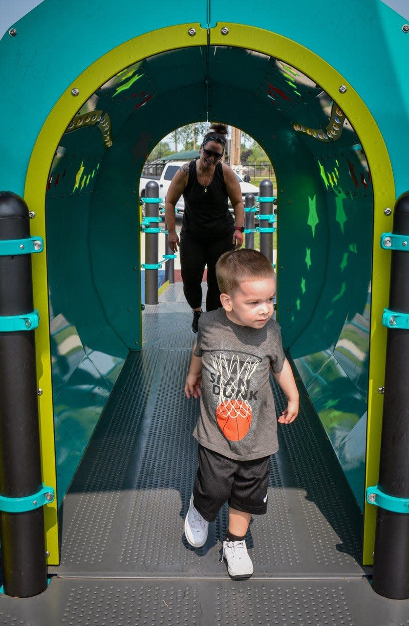 Carla Hammer follows her son, Tyler Nutter, 3, through a tunnel at Kiwanis Play Park.