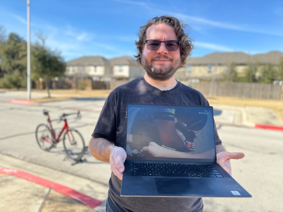 Steven Heller, a victim hit by a stolen car involved in a police chase, holds a laptop showing a moment after he was knocked off his bicycle that was captured on police body camera. (KXAN Photo/ Matt Grant)