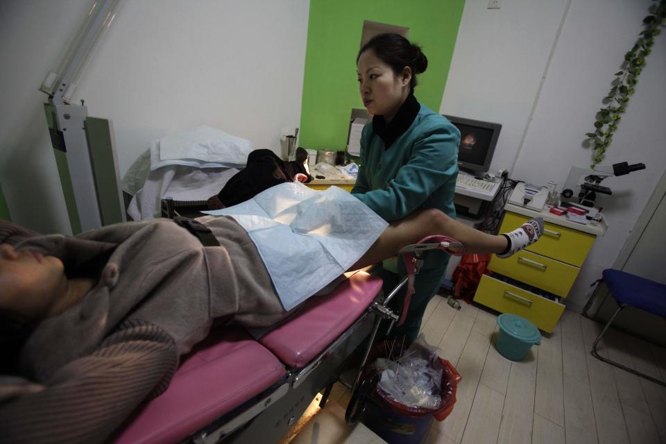 En esta foto tomada el lunes 13 de diciembre de 2010, una enfermera examina a "Nancy" Yin, embarazada de tres meses, en una clínica de aborto administrada por Marie Stopes International en Xi'an, en la provincia central china de Shaanxi. Si bien es difícil obtener datos completos, las cifras oficiales muestran que los abortos están aumentando, y los medios y expertos chinos dicen que muchos, si no la mayoría, de los que buscan el aborto son mujeres jóvenes y solteras. (Foto AP / Ng Han Guan)