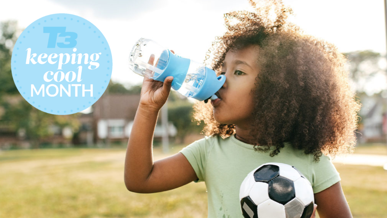  girl drinking water holding a football 