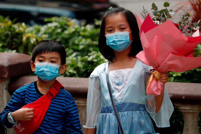 FILE PHOTO: Children wear face masks, following the outbreak of the novel coronavirus on Valentine’s Day in Hong Kong