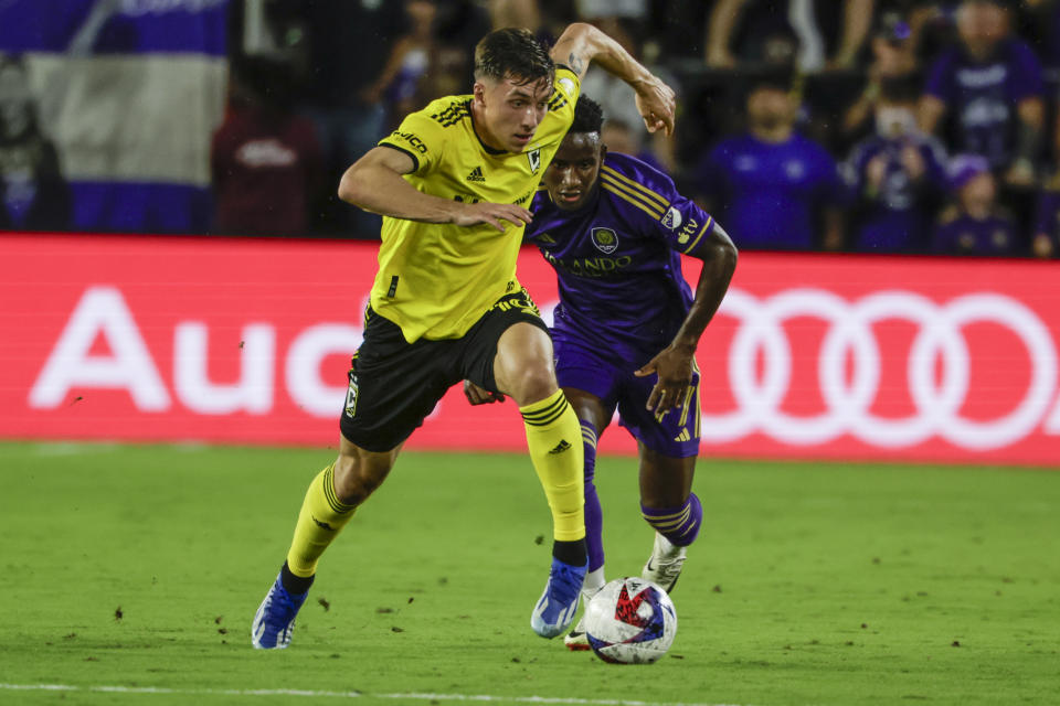 Columbus Crew defender Malte Amundsen, left, brings the ball down pitch defended by Orlando City forward Iván Angulo, right, during the first half of an MLS soccer playoff match, Saturday, Nov. 25, 2023, in Orlando, Fla. (AP Photo/Kevin Kolczynski)