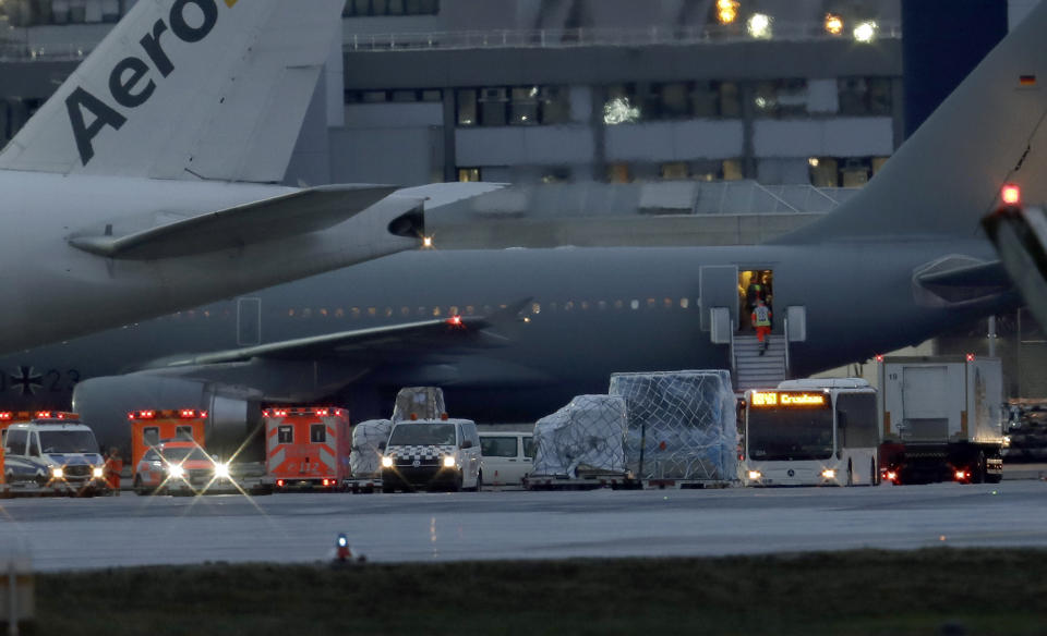 Ambulances and police cars stay next to an airplaine of the German air force with from China evacuated Germans aboard after its arrival at the Frankfurt Airport in Frankfurt, Germany, Saturday, Feb. 1, 2020. (AP Photo/Michael Probst)