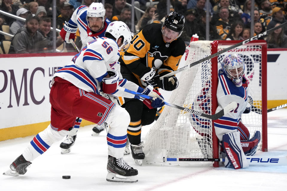 Pittsburgh Penguins' Drew O'Connor (10) loses the puck while being defended by New York Rangers' Erik Gustafsson (56) behind goalie Jonathan Quick during the second period of an NHL hockey game in Pittsburgh, Wednesday, Nov. 22, 2023. (AP Photo/Gene J. Puskar)