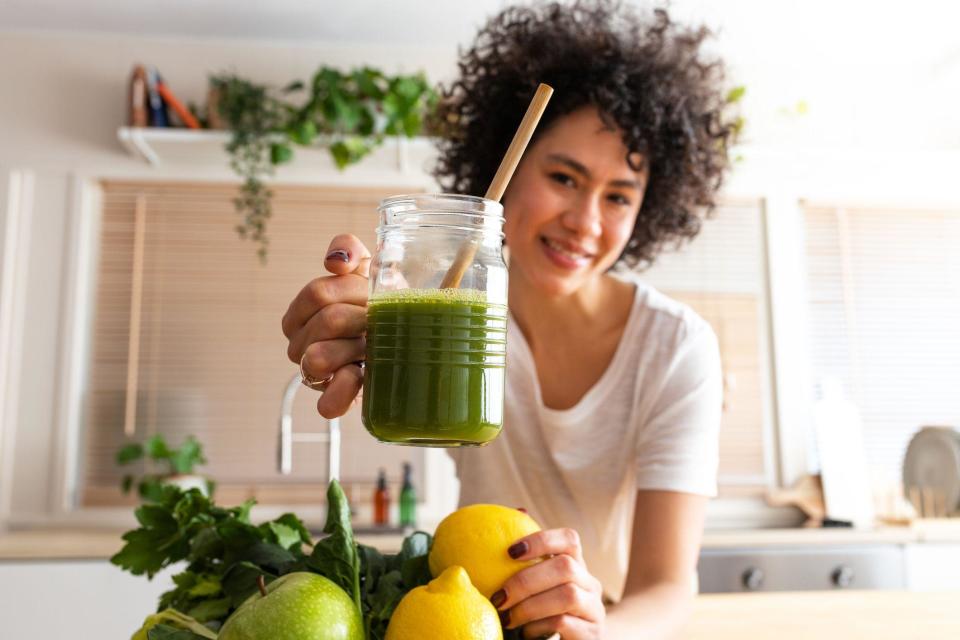 Woman hold cup and fruits