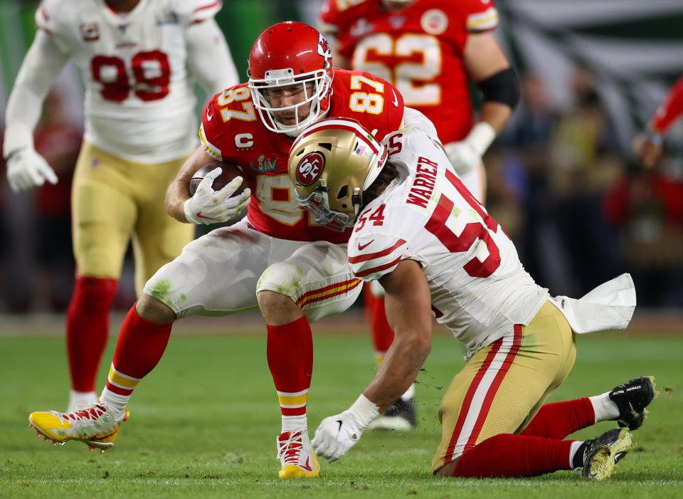 Kansas City Chiefs tight end Travis Kelce (87) runs after a reception in the third quarter against San Francisco 49ers linebacker Fred Warner (54) in Super Bowl LIV at Hard Rock Stadium.