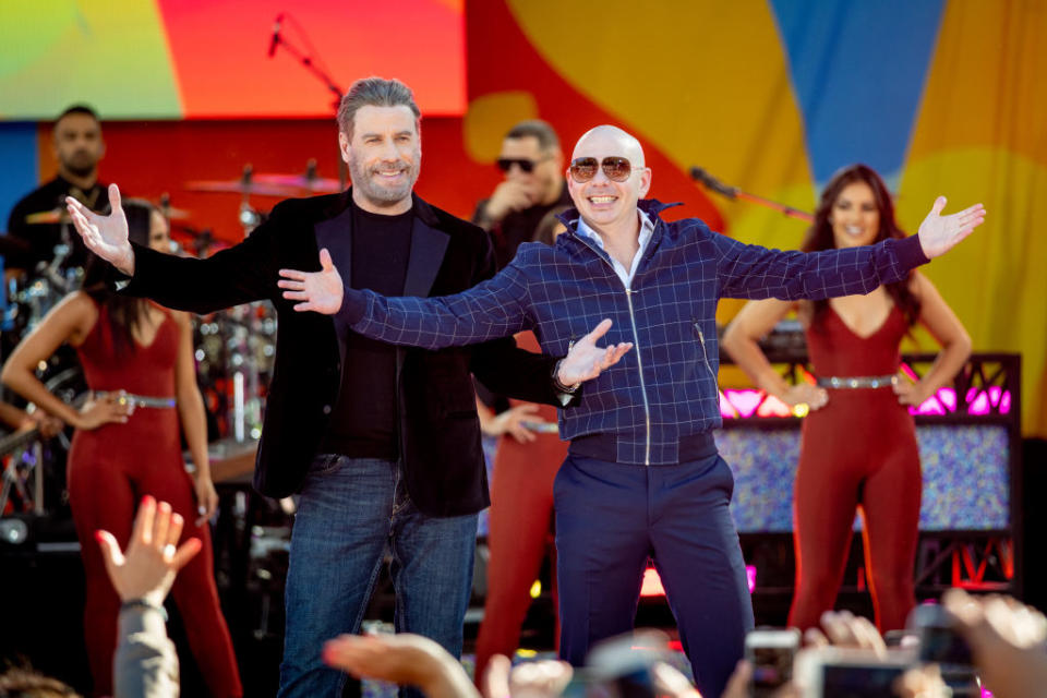 John Travolta onstage with Pitbull during the artist’s performance on ABC’s <em>Good Morning America</em> on June 15, 2018, at Central Park in New York City. (Photo: Roy Rochlin/Getty Images)