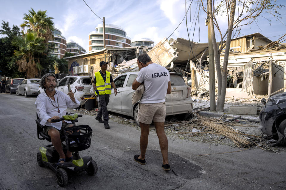 Image: Residents inspect damage from Hamas airstrikes in Tel Aviv on Sunday. (Oded Balilty / AP)