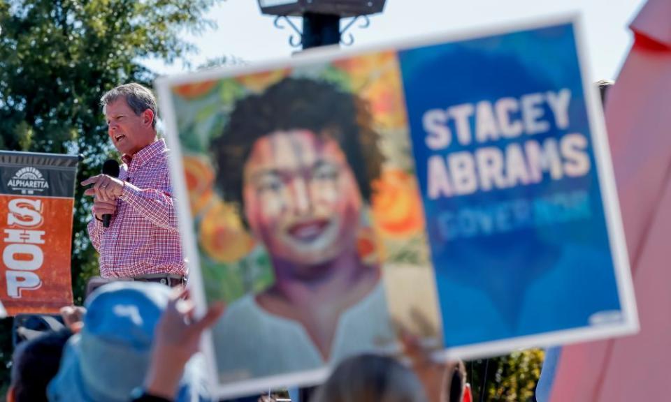 Republican Brian Kemp at a rally in Alpharetta, Georgia last week, as an Abrams supporter holds up a sign.