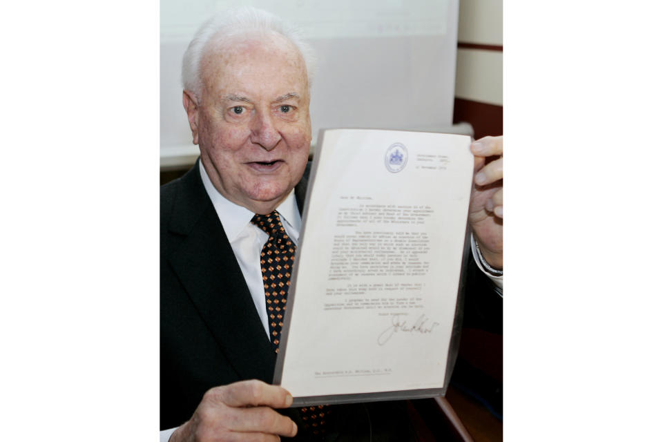 FILE - In this Nov. 7, 2005, file photo, former Australian Prime Minister Gough Whitlam holds up the original copy of his dismissal letter he received from then Governor-General Sir John Kerr on Nov. 11, 1975, at a book launch in Sydney, Australia. The High Court's majority decision in historian Jenny Hocking’s appeal on Friday, May 29, 2020 overturned lower court rulings that more than 200 letters between the monarch of Britain and Australia and Governor-General Sir John Kerr before he dismissed Prime Minister Gough Whitlam’s government were personal and might never be made public. (AP Photo/Mark Baker, File)