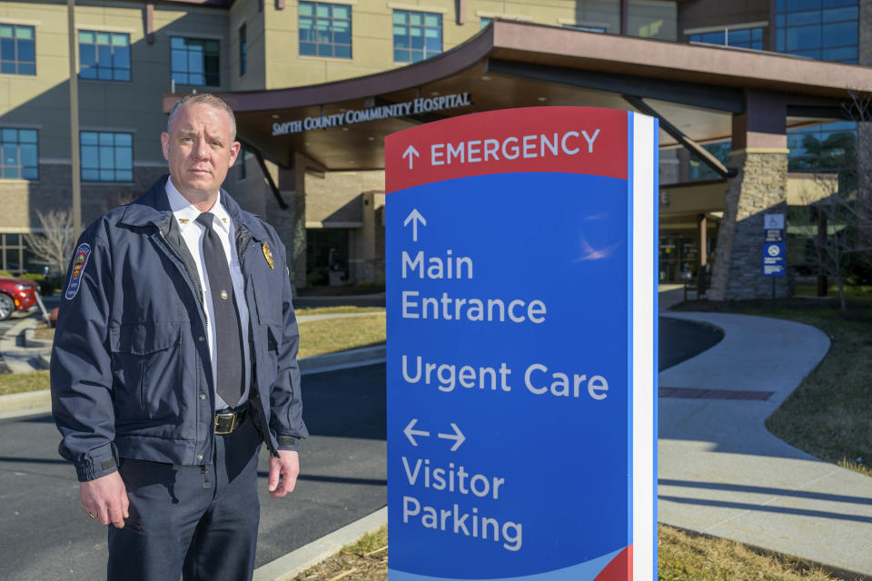 Marion Police Chief John Clair poses outside the Emergency Room at Smyth County Community Hospital, Monday, Feb. 5, 2024, in Marion, Va. Clair, chief of the small Appalachian town, spends his days consumed by a growing problem: the frequency with which his officers are tapped to detain, transport and wait in hospitals with people in the throes of a mental health crisis. (AP Photo/Earl Neikirk)