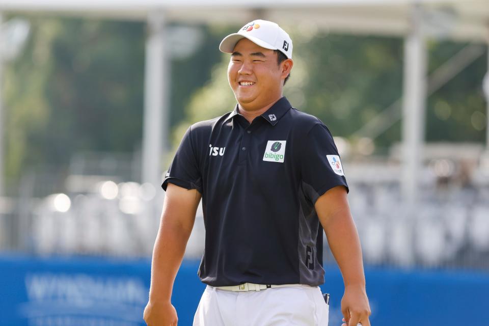 Joohyung Kim laughs after making a par putt on the 18th hole during Friday’s second round of the Wyndham Championship at Sedgefield Country Club.