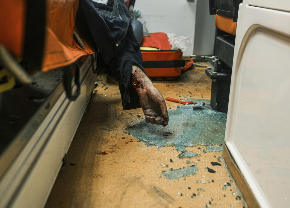 The dead body of rescue worker lies inside the ambulance after Russian drone strikes on residential neighbourhood in Kharkiv, Ukraine, on Thursday, April 4, 2024. (AP Photo/George Ivanchenko)