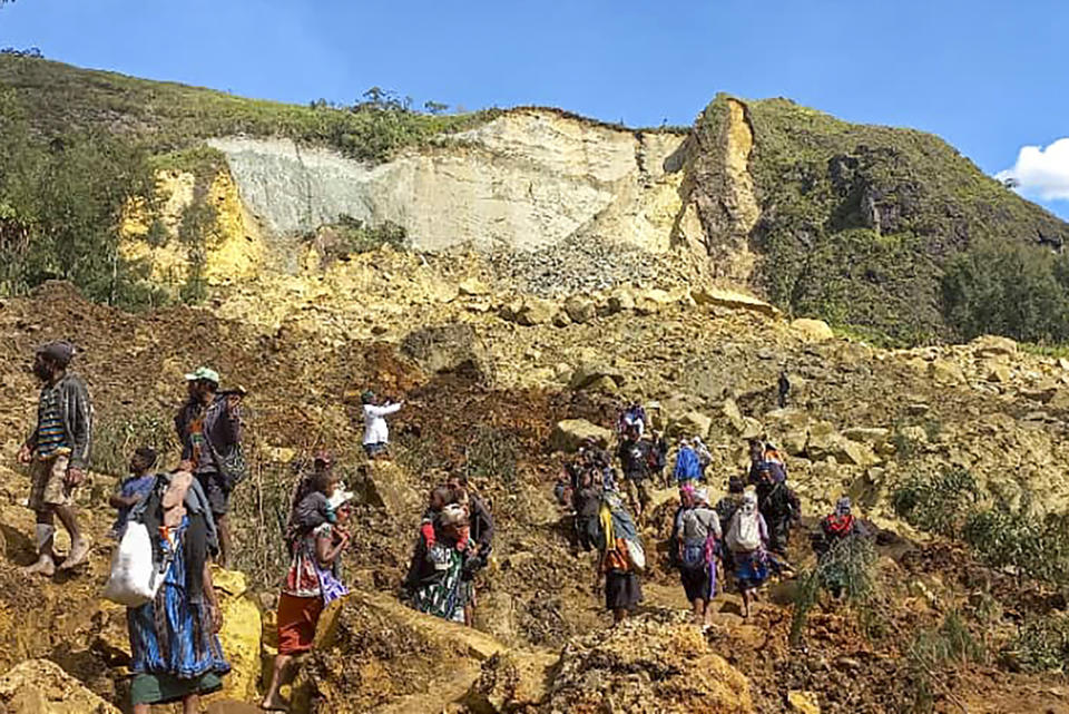 In this photo provided by the UNDP Papua New Guinea, villagers search through a landslide in Yambali village in the Highlands of Papua New Guinea, Sunday, May 26, 2024. The International Organization for Migration feared Sunday the death toll from a massive landslide is much worse than what authorities initially estimated. (Kafuri Yaro/UNDP Papua New Guinea via AP)