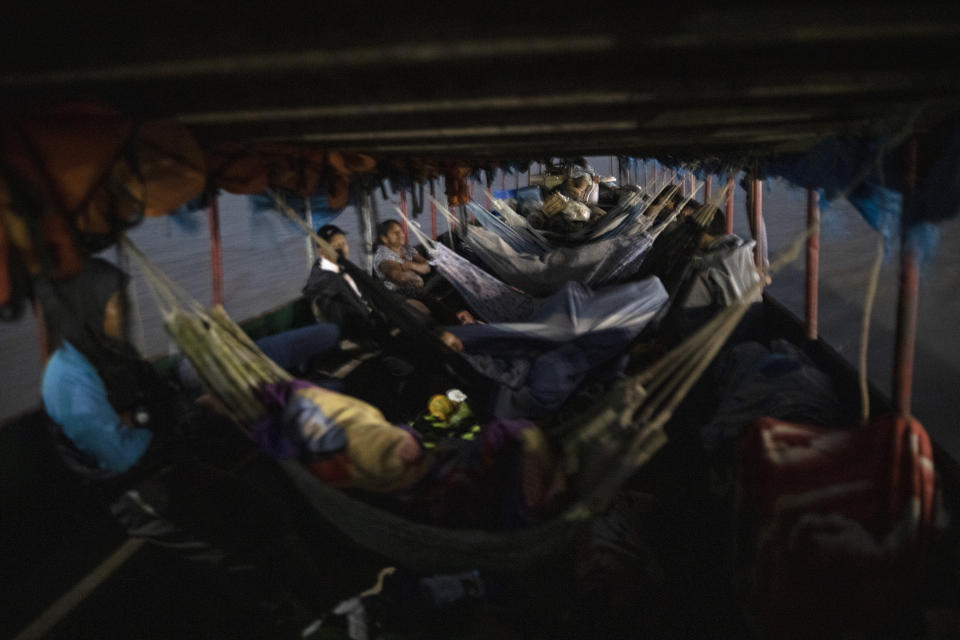 Amazonian residents rest in hammocks as they travel on a public boat to Pucallpa, in Peru's Ucayali region, Peru, Monday, Oct. 5, 2020. The Ucayali region located along a muddy river has long seen periodic dengue outbreaks, though this year's figures are already three times that seen in 2019. In the city of Pucallpa, doctors say they are beginning to encounter patients with the double diagnosis of COVID-19 and dengue. (AP Photo/Rodrigo Abd)