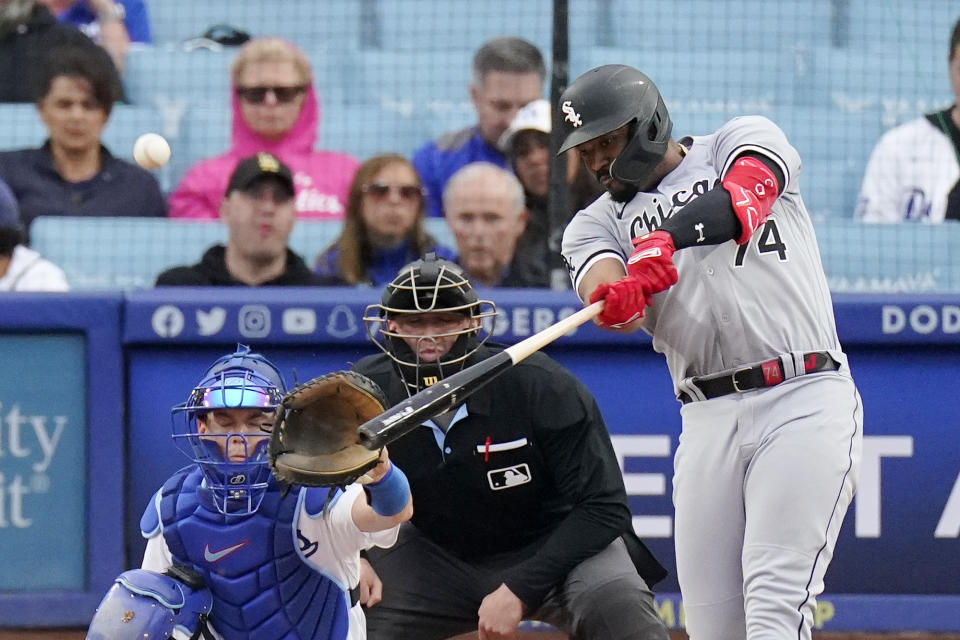 Chicago White Sox's Eloy Jimenez, right, hits a solo home run as Los Angeles Dodgers catcher Will Smith, left, watches along with home plate umpire Jacob Metz during the first inning of a baseball game Thursday, June 15, 2023, in Los Angeles. (AP Photo/Mark J. Terrill)