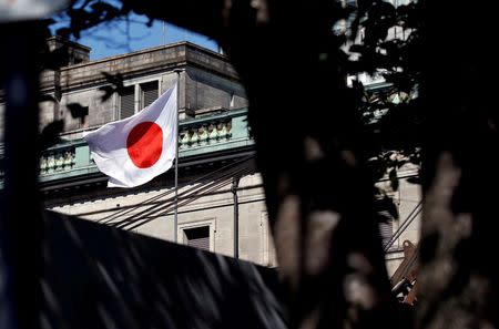 FILE PHOTO: A Japanese flag flutters atop the Bank of Japan building under construction in Tokyo, Japan, September 21, 2017. REUTERS/Toru Hanai/File Photo