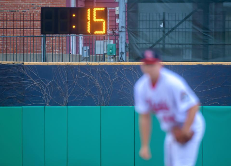 A pitch clock runs in the background as Peoria Chiefs pitcher Austin Love prepares to throw against the Great Lakes Loons in the Chiefs' home opener Tuesday, April 12, 2022 at Dozer Park in Peoria. 