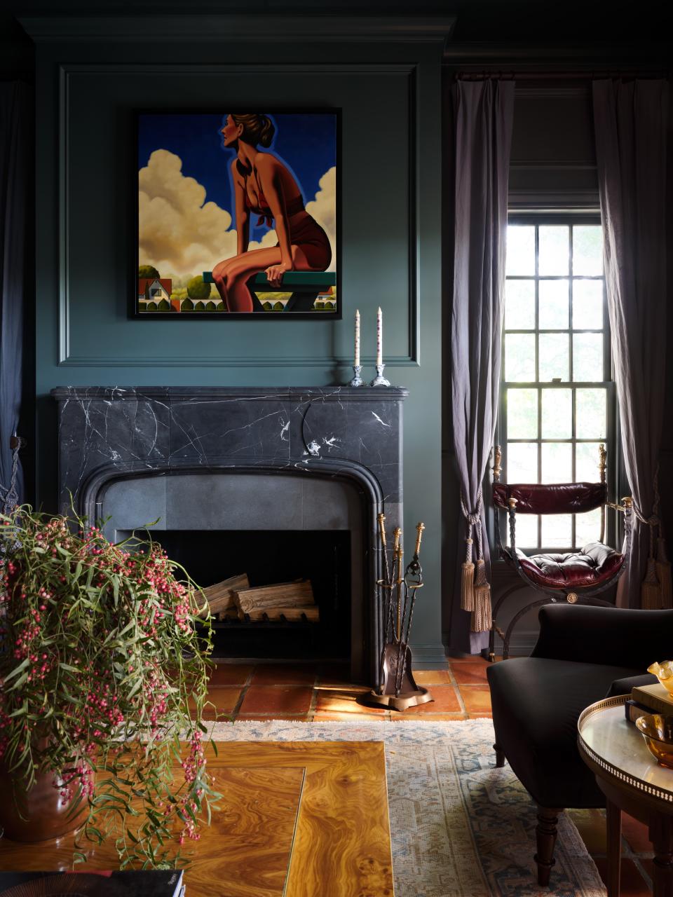 The parlor in this traditional Texas limestone house designed by Scheer & Co. features antique brass, iron, and leather campaign chairs sourced at the Round Top Antiques Fair in Texas and a French Bouillotte marble-topped side table found at High Point Market in North Carolina.