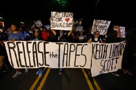 Protesters hold signs while marching to demonstrate against the police shooting of Keith Scott in Charlotte, North Carolina, U.S., September 23, 2016. REUTERS/Jason Miczek TPX IMAGES OF THE DAY