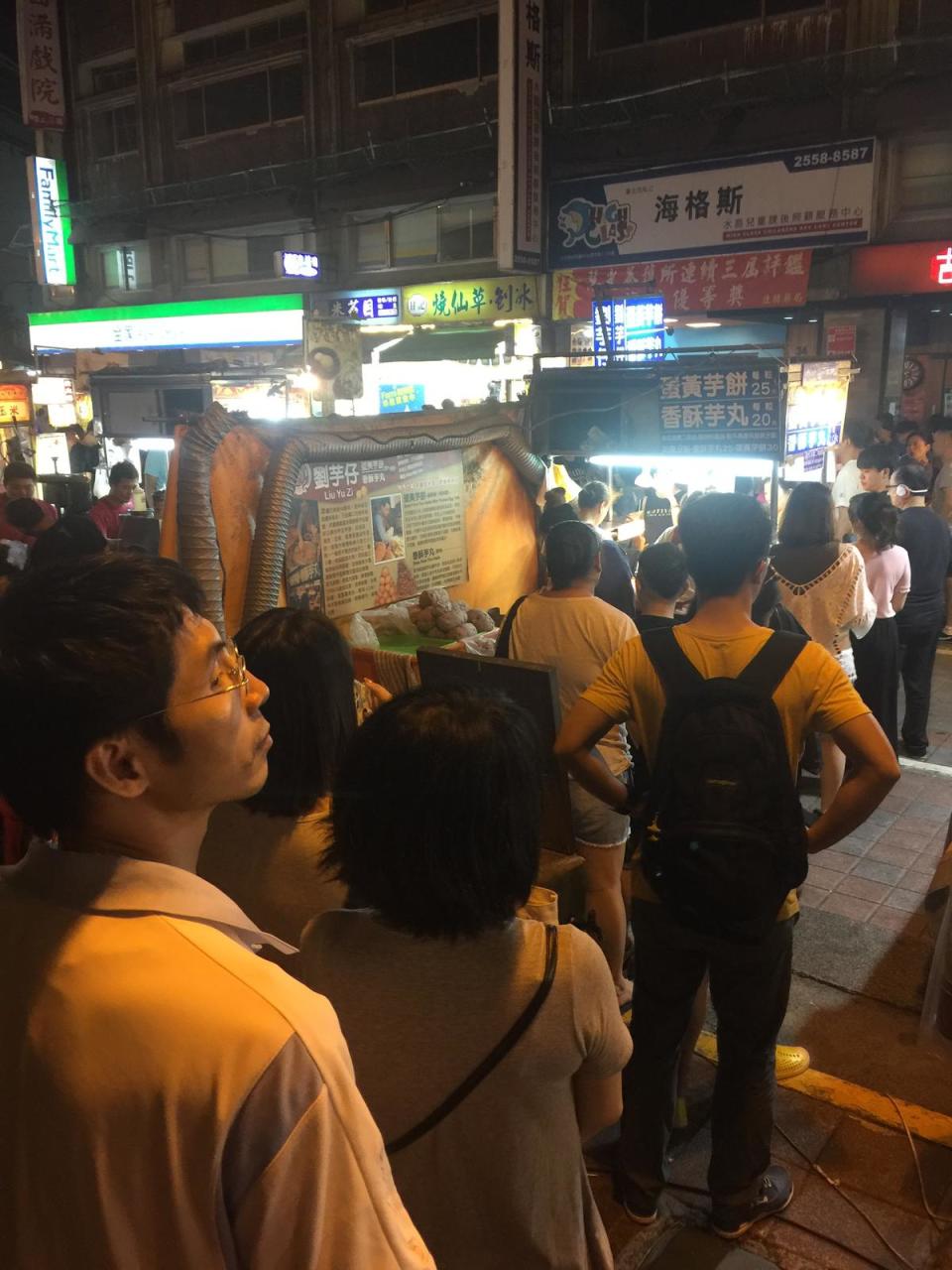 排隊人龍從攤旁延伸到蓬萊國小圍牆邊，以免妨礙夜市交通。