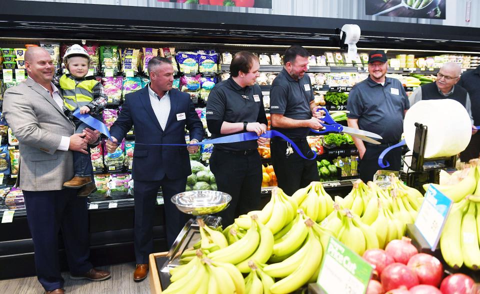 Fareway CEO Reynolds Cramer, 3-year-old Ogden resident Clark Lage, and other Ogden Fareway management team members cut the ribbon during the new store's grand opening.