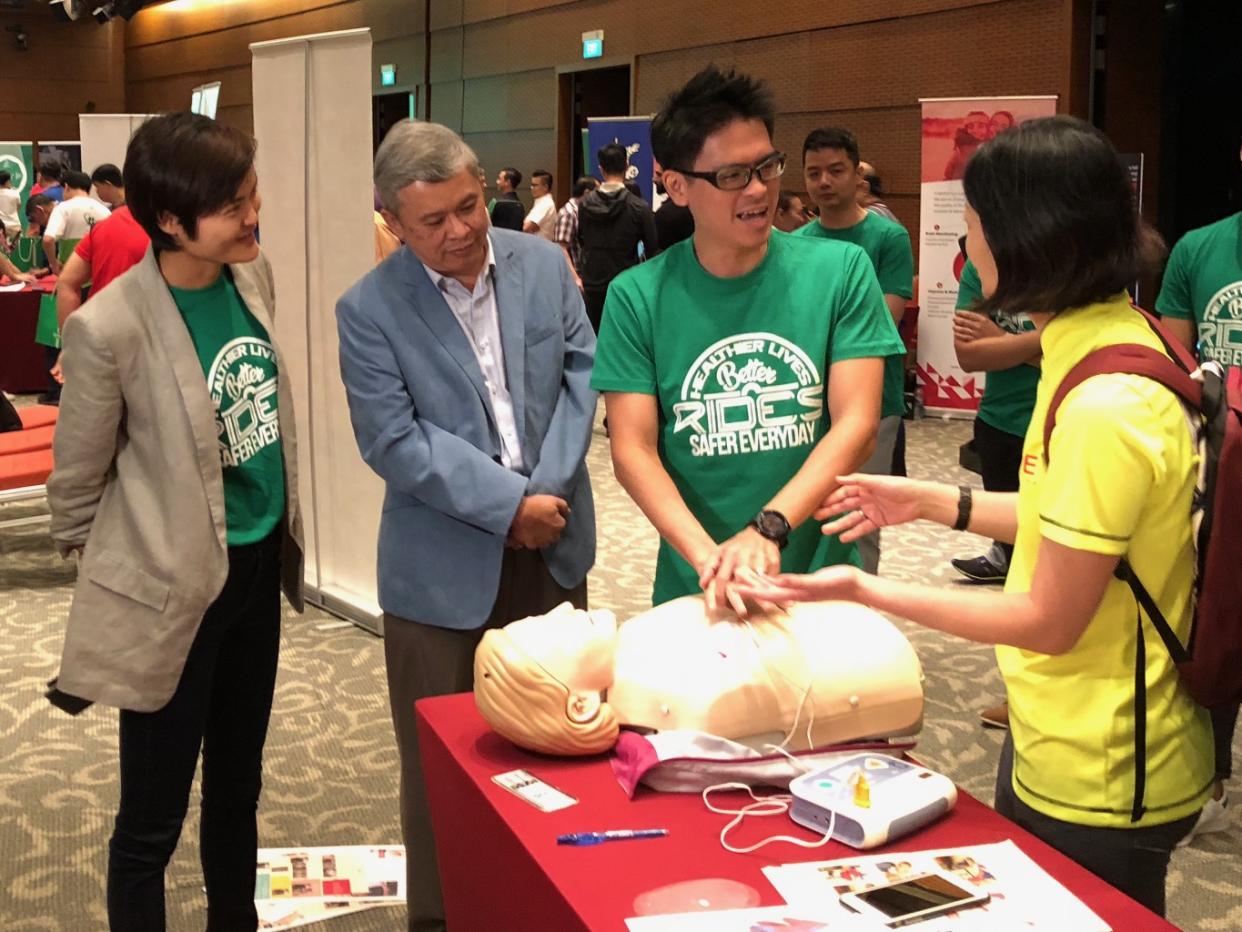 (L-R) Grab co-founder Tan Hooi Ling and National Private Hire Vehicles Association executive advisor Ang Hin Kee look on as Grab Singapore head Lim Kell Jay gets pointers on administering CPR from Dr Jade Kua, Ministry of Health, on Tuesday, 16 October 2018. PHOTO: Nicholas Yong/Yahoo News Singapore