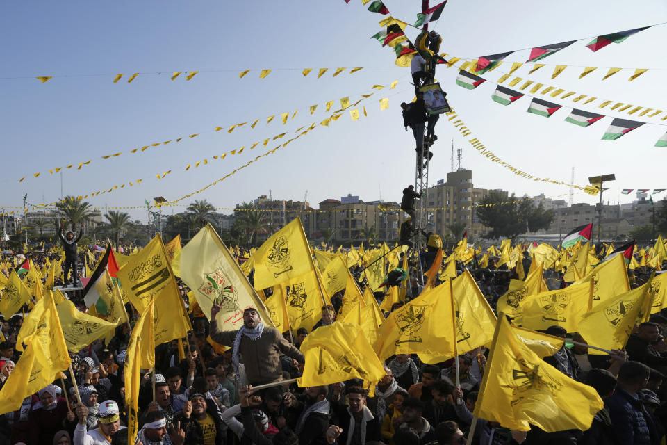 Palestinian Fatah supporters chant slogans and wave the movement's flags during a rally marking the 58th anniversary of Fatah movement foundation at the Unknown soldier square in Gaza City, Saturday, Dec. 31, 2022. Hundreds of thousands of Palestinians thronged a Gaza City park Saturday to mark the 58th founding anniversary of Fatah party, a rare show of popularity in the heartland of the militant Hamas group, Fatah's main rival. (AP Photo/Adel Hana)