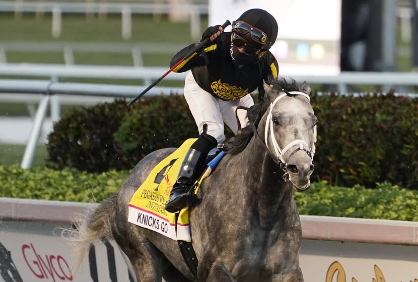 Joel Rosario celebrates after Knicks Go won the Pegasus World Cup Invitational horse race.