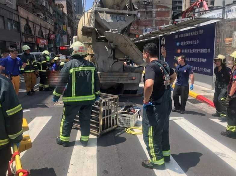 現場人員想把水泥車抬起救出婦人，但水泥車太重。翻攝畫面