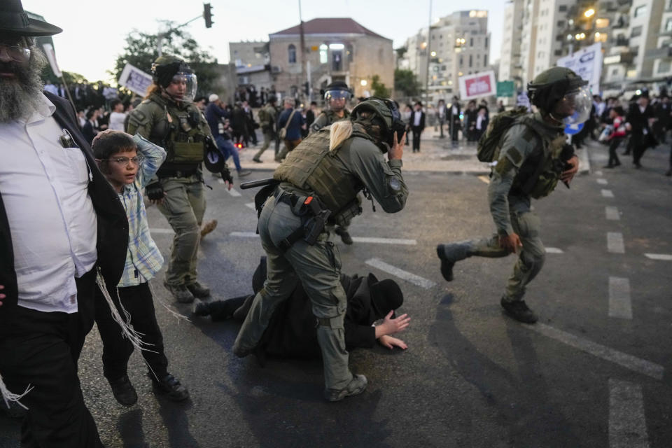 Ultra-Orthodox Jewish men clash with police during a rally against army recruitment in Jerusalem on Sunday, June 30, 2024. Israel's Supreme Court last week ordered the government to begin drafting ultra-Orthodox men into the army, a landmark ruling seeking to end a system that has allowed them to avoid enlistment into compulsory military service. (AP Photo/Ohad Zwigenberg)