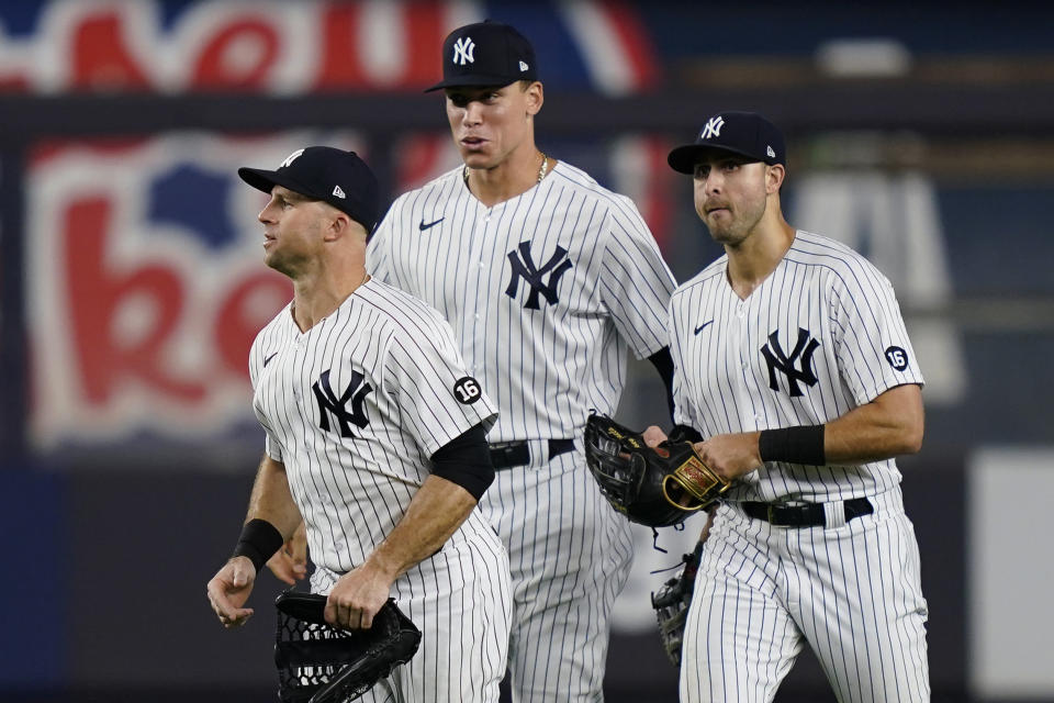 New York Yankees center fielder Brett Gardner, left, right fielder Aaron Judge, center, and left fielder Joey Gallo, right, celebrate after the team's baseball game against the Cleveland Indians, Friday, Sept. 17, 2021, in New York. (AP Photo/John Minchillo)