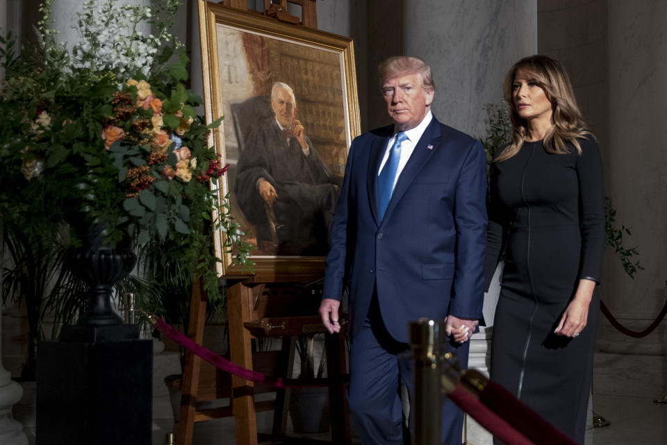 President Donald Trump and first lady Melania Trump walk past a painting of the late Supreme Court Justice John Paul Stevens after they pay their respects as he lies in repose in the Great Hall of the Supreme Court in Washington, Monday, July 22, 2019. (AP Photo/Andrew Harnik, pool)