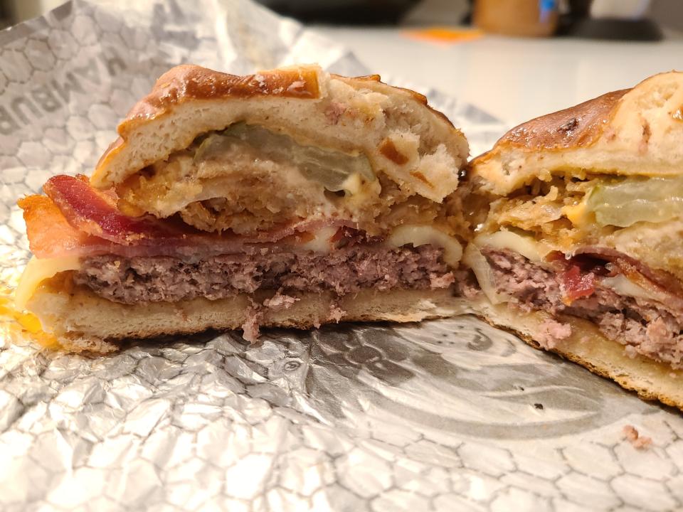 wendys pretzel bacon pub cheeseburger cut in half on white wrapper